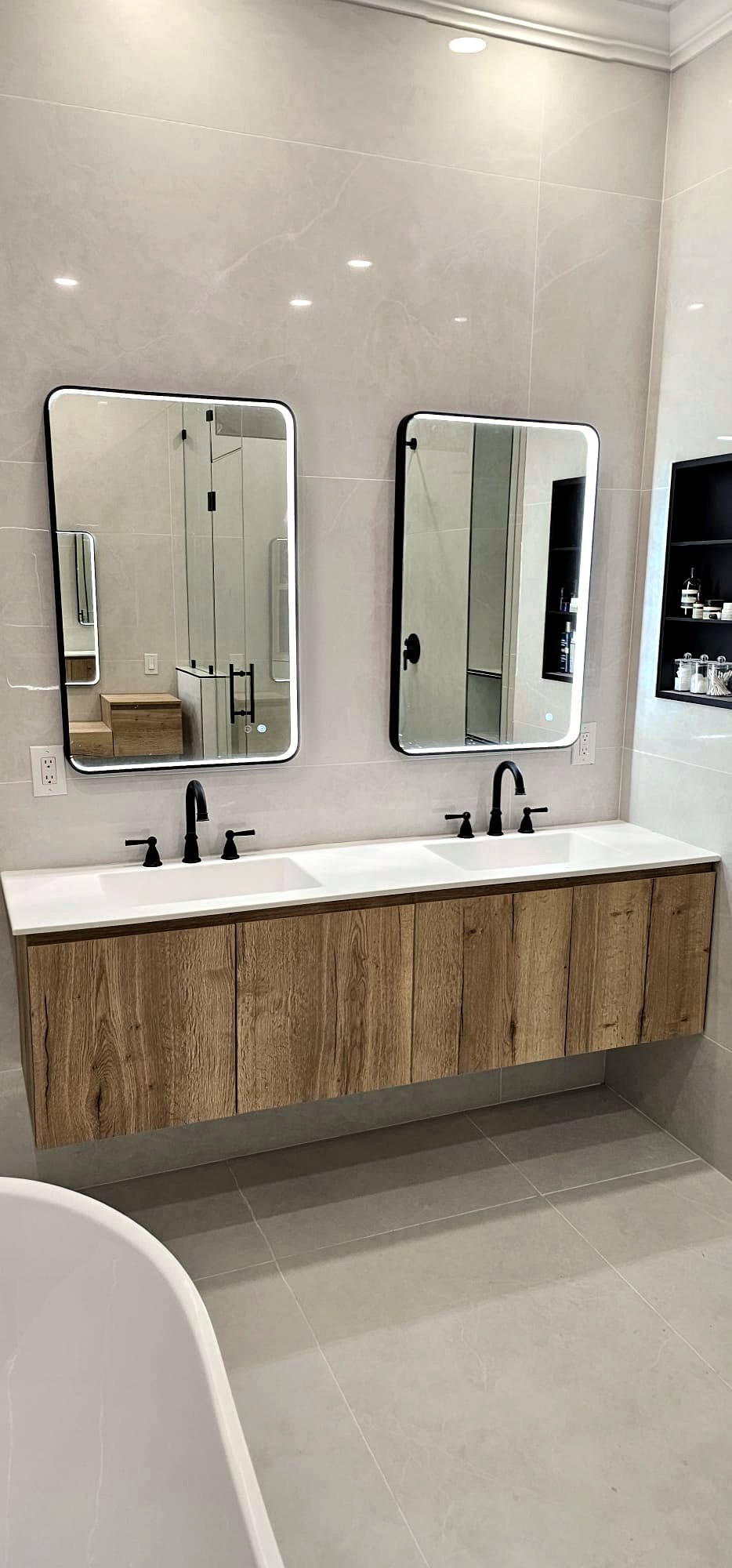 Bathroom with floating oak double vanity and black LED mirrors