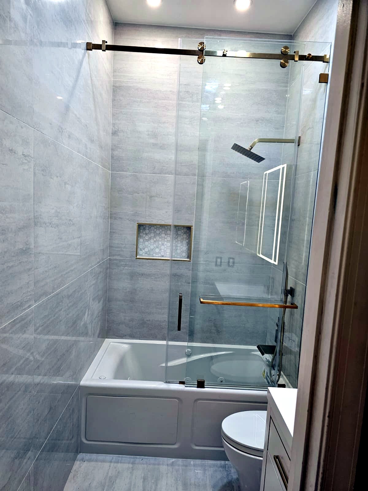 Tub and glass shower combination with brushed gold fixtures