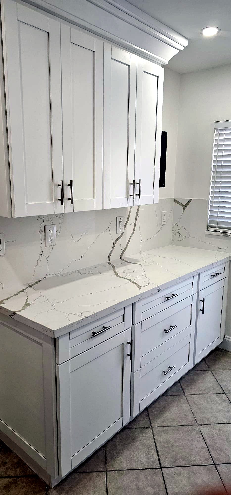 White shaker kitchen with Calacatta quartz counters and backsplash in South Florida