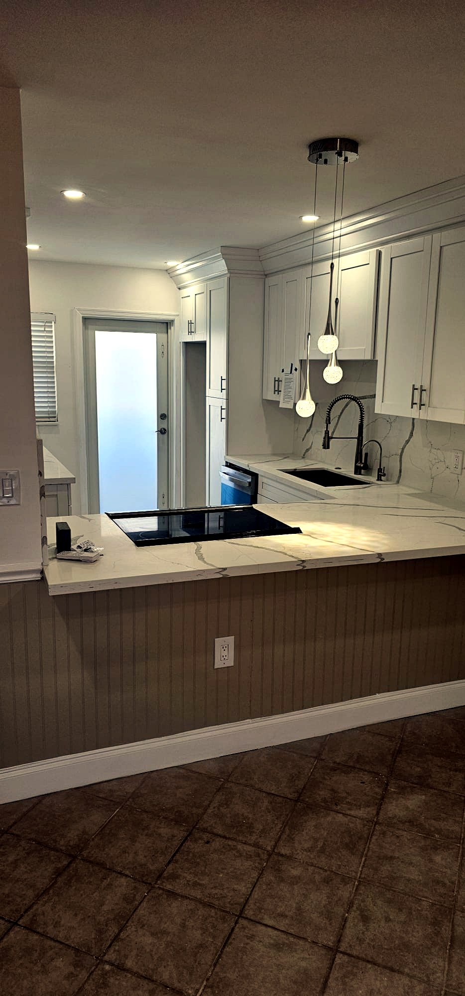 Bright white kitchen remodel with peninsula and quartz waterfall