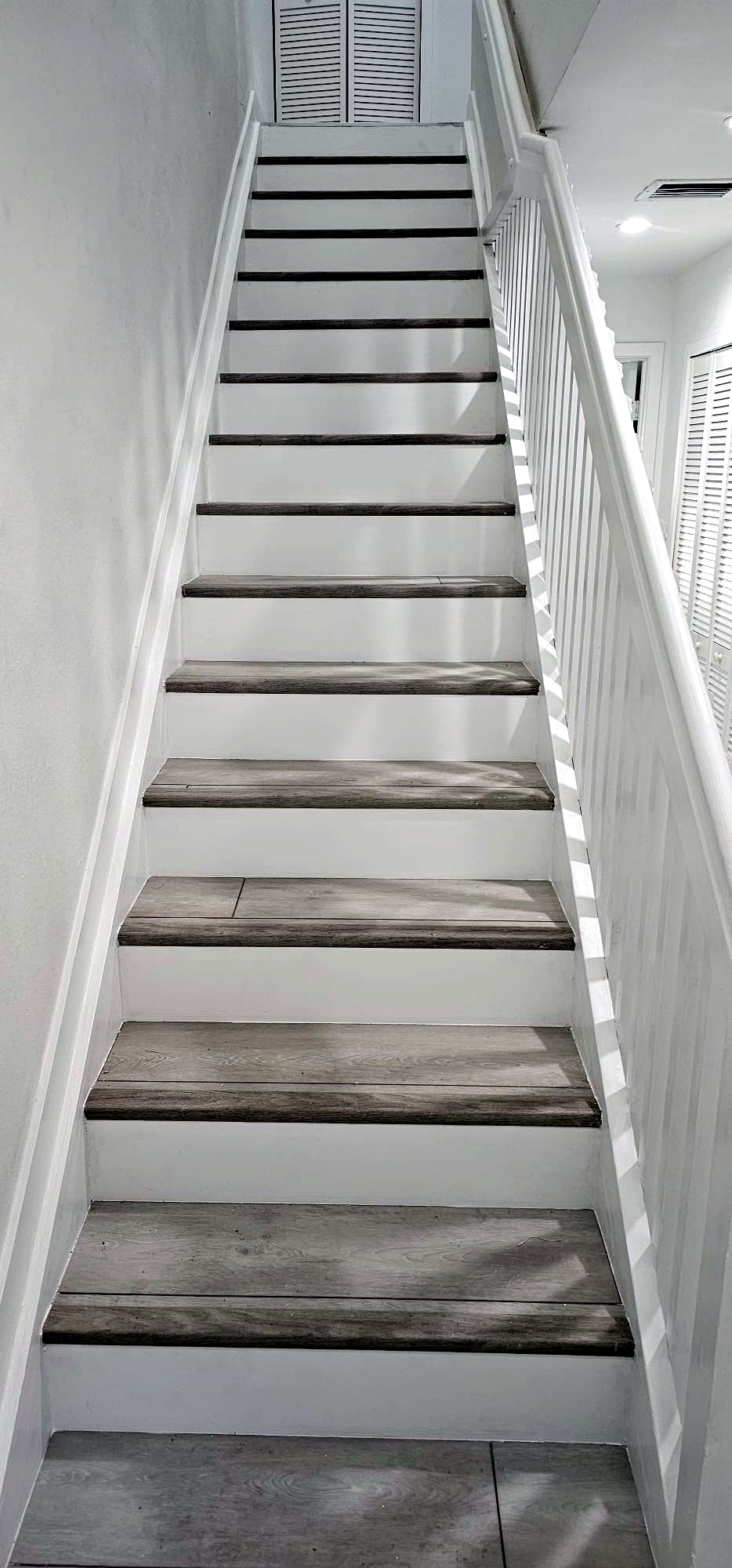 Refinished staircase with gray wood treads and white risers